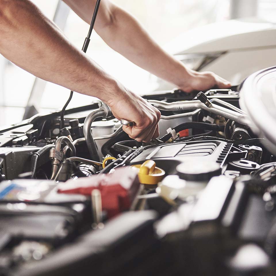 Auto mechanic working in garage. Repair service.