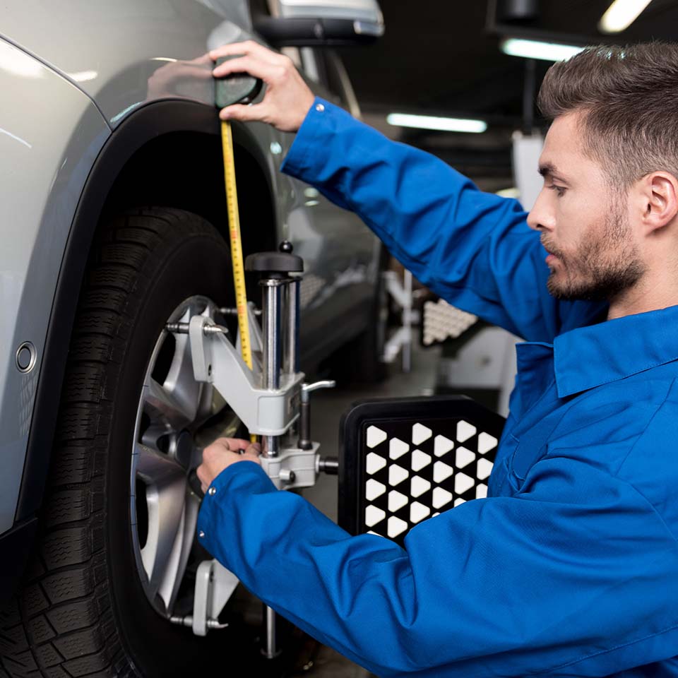 Professional mechanic adjusting automobile wheel alignment.