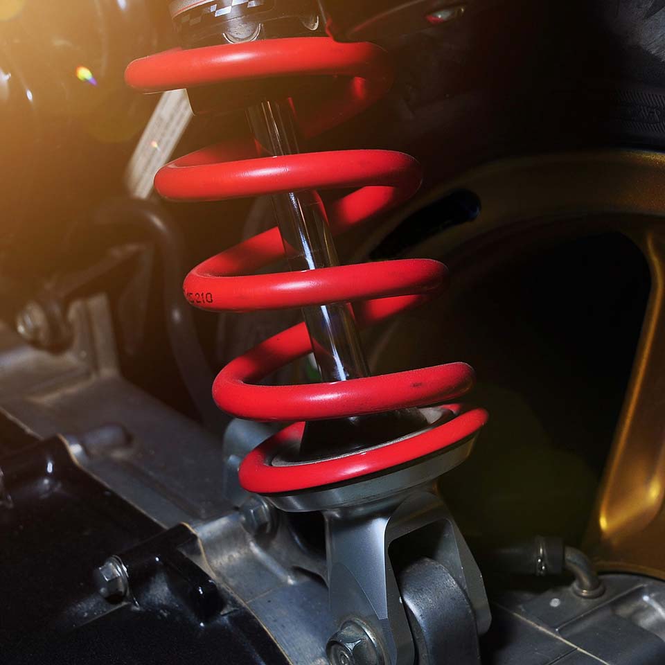 Close-up of red shock absorber of motorcycle. Focus on suspension